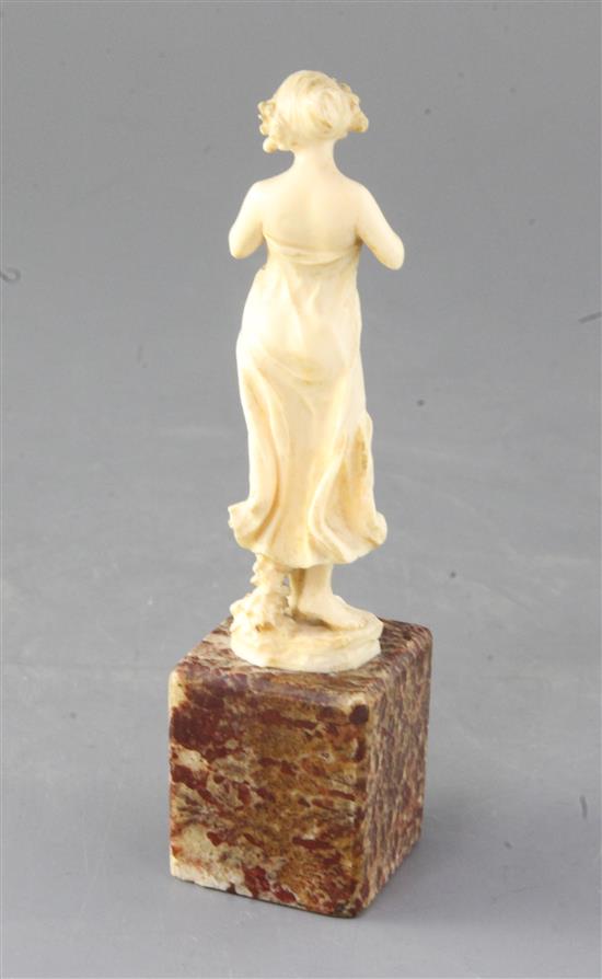 An Art Nouveau French ivory carved figure of a lady with a dove, height 6.5in.